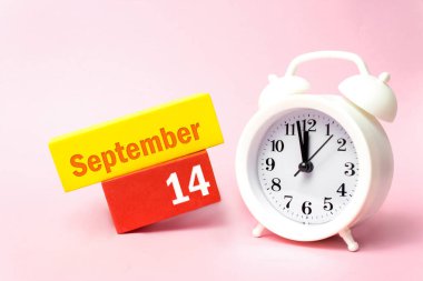 14 Eylül. Ayın 14 'ü, takvim tarihi. Pastel pembe arka planda beyaz çalar saat. Sonbahar ayı, yılın günü konsepti.