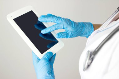Sağlık hizmetlerinin bilgisayara geçirilmesi. Tıp doktoru tabletteki elektronik tıbbi kayıtlara dokunuyor. Tıbbi bakım teknolojisi yeniliği, ilaç keşfi ve sağlık hizmetleri verileri