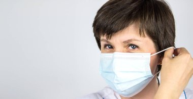Salgın sona erdi. Doktor maskeyi takıyor ya da çıkarıyor. Covid-19 'u durdurun. Koronavirüsü bitir. Kilitlemeyi sonlandır.