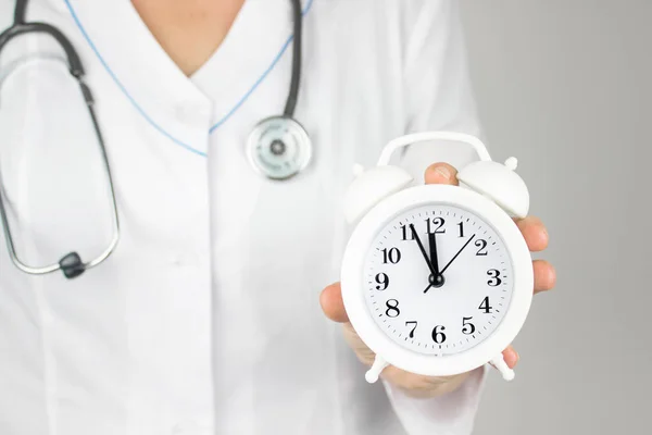 Time is crucial life saver. Concept for timing, medical and healthcare. Alarm clock in doctor hand. Time to take care of your health