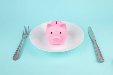 Çatal ve bıçaklı domuz kumbarası, tasarruf tüketicisi konsepti. Harcama Birikimleri, Gıda harcamaları.