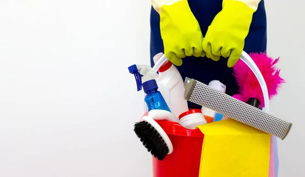 Beyaz arka planda yeşil eldivenlerle ev temizleme ürünleri üst üste yığılıyor. Temizlik servisini kutsa.