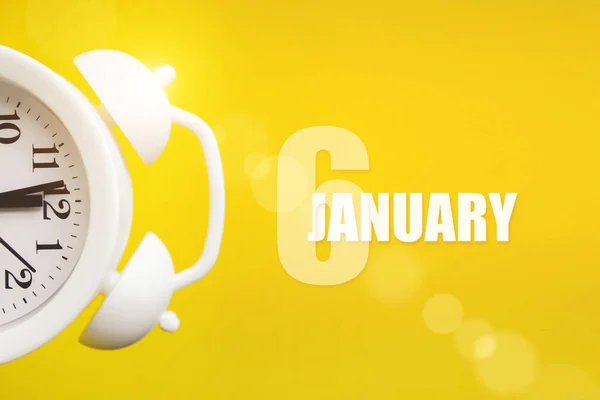 January 6th. Day 6 of month, Calendar date. White alarm clock on yellow background with calendar day. Winter month, day of the year concept