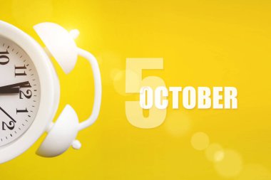 5 Ekim. Ayın 5 'i, takvim tarihi. Takvim günüyle birlikte sarı arka planda beyaz çalar saat. Sonbahar ayı, yılın günü konsepti.