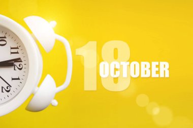18 Ekim. Ayın 18 'i, takvim tarihi. Takvim günüyle birlikte sarı arka planda beyaz çalar saat. Sonbahar ayı, yılın günü konsepti.