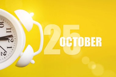 25 Ekim. Ayın 25 'i, takvim tarihi. Takvim günüyle birlikte sarı arka planda beyaz çalar saat. Sonbahar ayı, yılın günü konsepti.