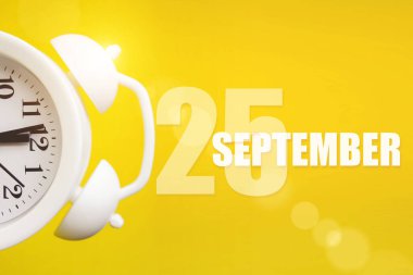 25 Eylül. Ayın 25 'i, takvim tarihi. Takvim günüyle birlikte sarı arka planda beyaz çalar saat. Sonbahar ayı, yılın günü konsepti.