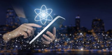 Bilim konsepti olarak atom molekülü. Şehrin karanlık arka planında dijital hologram atom işaretli beyaz tablete dokun. Atom molekülü soyut.
