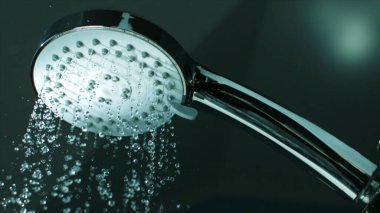 Banyoya düşen bir damla suyla duş başlığı.