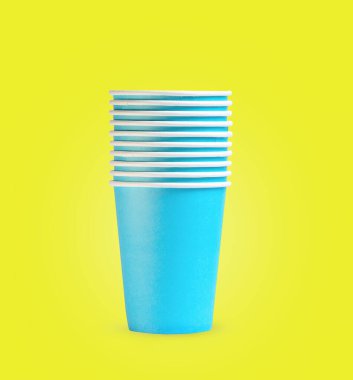 Sarı arkaplanda mavi kağıt bardaklar