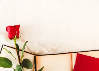 Red rose next to open books and closed books on white background. Perfect for Sant Jordi or for Valentine's Day. Sant Jordi 2023.