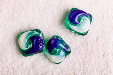 Beyaz havlu üzerinde yıkanmak için çözünebilir jel kapsülü. Yıkama tozu yerine.