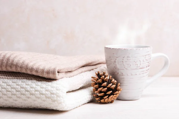 Warme Winterpullover Und Eine Tasse Heißen Tee Auf Weißem Holzgrund — Stockfoto