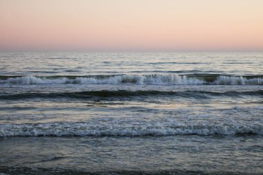 Akşam denizinde dalgalar. Pembe günbatımı. Deniz Burnu.