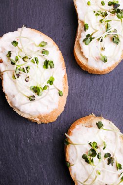 Siyah arka planda mikroyeşil turplu tost..