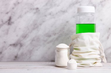 Beyaz protein tozu yığını. Ölçme kaşığı ve mermer arka planda şişe var..