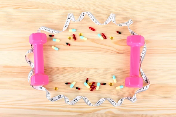 Dieta, fita métrica em torno dos pesos e pílulas — Fotografia de Stock