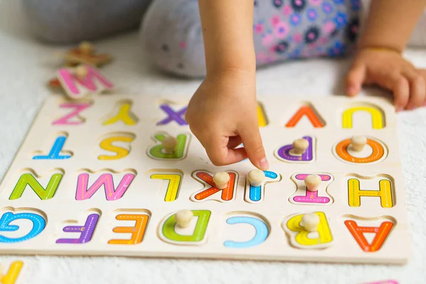 学校の準備だ 最年少のための教育 幼稚園での就学前教育 小さい子供は家の床のアルファベットからパズルを作る 子供のためのカラー英語のアルファベット ボード上のパズル — ストック写真