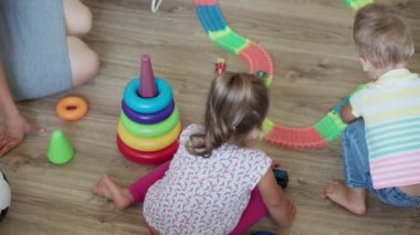 Çocukluk, oyunlar, küçük, gelişim konsepti - yeni doğmuş bebek ve kız kardeşle annenin çocuk oyun odasında sihirli yollarla oynaması. Anaokulu kardeşleri karantinada eğleniyor.