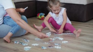 Çocukluk, oyunlar, yetiştirme ve geliştirme konsepti. Küçük çocukların genel planı. Erkek kardeş ve kız kardeş ile anne çocuk oyun odasında bulmaca çözer. Anaokulu kardeşlerinin karantinadaki evleri eğlencelidir.