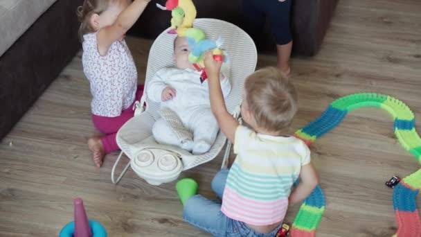 Dětství, hry, výchova a rozvoj koncept - top pohled na novorozence a děti chlapec a sestra hrát s hračkami magické cesty v dětském pokoji. Sourozenci se baví doma na karanténě — Stock video