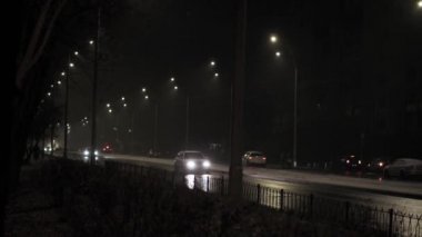 Hava tahmini, anomali, acil durum, element, kış konsepti - dengesiz bir kar fırtınası. Gece yolundaki sokak lambasının ışığında kar taneleri düşüyor. Kiev 'deki ilk kar