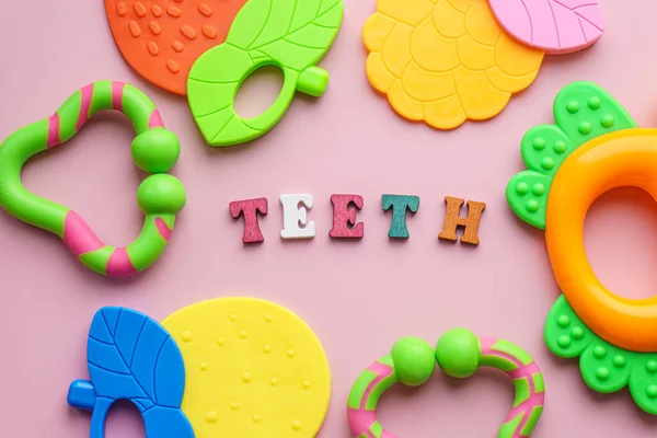 Dzieciństwo, opieka, higiena, niemowlęta - słowo "zęby dziecka" ułożone z kolorowych drewnianych liter na pastelowym różowym tle. duża kolorowa zabawka wykałaczka. kisd personel ząbkowanie przestrzeń kopia — Zdjęcie stockowe