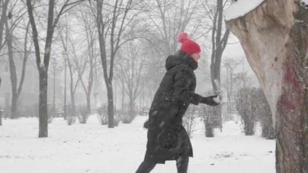 Invierno, vacaciones, juegos, conceptos familiares Dos niños preescolares felices hermanos vestidos con sombreros y manoplas con mamá jugando hacen que la bola de nieve en las nevadas en el clima de temporada fría en el parque al aire libre — Vídeos de Stock