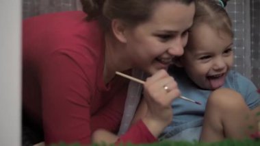 Çocukluk, annelik, yaratıcılık, doğa, sanat, bahar, yaz konsepti - 3-4 yaşlarında küçük kızı olan genç bir annenin pencere camına çizimi. kadın ve anaokulu kızı ağaç boyuyorlar..