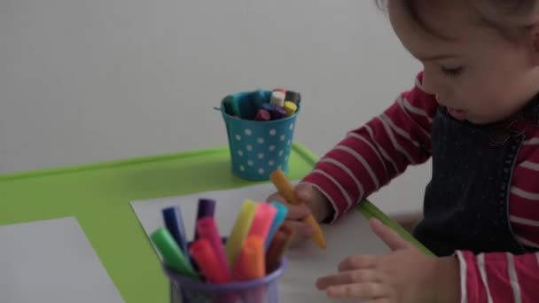 Kunst, Bildung, Kindheit, Konzepte - kleine fröhliche, smarte Vorschulmädchen im Vorschulalter zeichnen mit Filzstiften und Bleistiften am heimischen Tisch. Smart Kind malt drinnen — Stockvideo