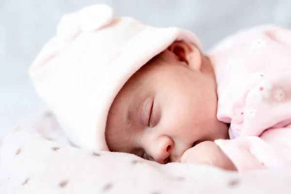 Infância, cuidado, maternidade, conceitos de saúde - Fechar-se Um pouco de paz recém-nascido menina calma no chapéu rosa dorme descansando tirar cochilo profundo que coloca na barriga no ninho de travesseiro cobertor quente macio com olhos fechados — Fotografia de Stock