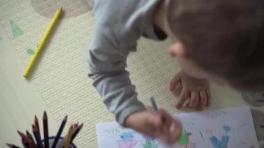 Çocukluk, Sanat, Eğitim, Yaratıcılık konsepti - anaokulu zeki yaratıcı çocuk 2-3 yıl renkli kalemlerle boyalar çiziyor aile yazının resmi, ev içinde gökkuşağı.