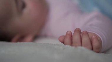 Bebeklik, Rahatlama, Tatlı Rüyalar, Annelik, Aile Konsepti - bebek minicik ellerini rüya gibi ellerle hareket ettir. 9-12 aylık küçük çocuk battaniyeyle kaplı beyaz yatakta uyuyor. Öğle Yemeği Uyku Kipi