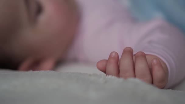 Spädbarn, avkoppling, söta drömmar, moderskap, familj koncept - baby flytta hennes lilla hand i drömmen hand. Liten 9-12 månader gammalt barn barn sover på vit säng täckt i filt. Lunchtid Sömnläge — Stockvideo