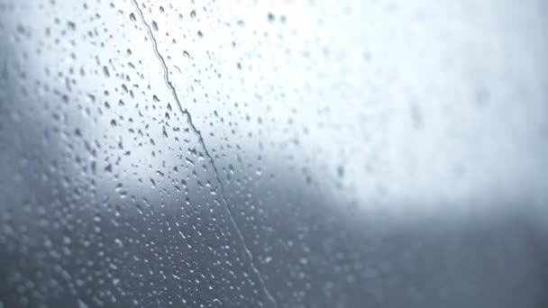 Transporte, carretera, ferrocarril, paisaje, concepto de comunicación: primer plano goteos de lluvia fluyen por el cristal de la ventana del tren de alta velocidad. viajar por el campo en tren. arroyos corrientes de fondo de agua — Vídeo de stock