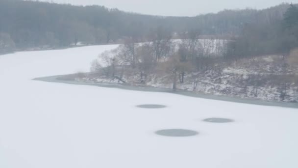 Trasporto, strada, ferrovia, paesaggio, comnication, concetto - vista da finestra di treno di velocità su paesaggio di campo coperto dalla neve naturale e foresta durante bufera di neve invernale. viaggiare in campagna in treno — Video Stock