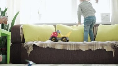 Çocukluk, aile kavramı - üç aktif kardeş çocuk evde eğleniyor. Küçük tatlı çocuklar oyun odasında yerde oyuncaklarla oynuyorlar. Kardeş karantinada eğleniyor..