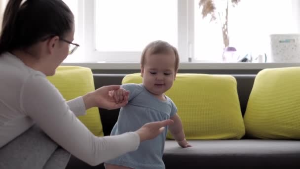 Auténtica toma de cerca de la joven madre neo caucásica que se mantiene en brazos y acaricia al bebé recién nacido en el vivero por la mañana. bebé, maternidad, maternidad, paternidad, infancia, vida, concepto de autenticidad — Vídeo de stock