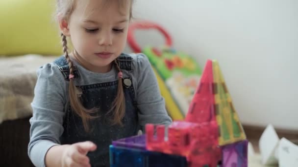 Barndom, familj, moderskap, föräldraskap koncept - unga glada barn njuta av att spela kreativa spel magneter block bygger slott. Två syskon har kul tillsammans i lekrummet på karantänen — Stockvideo
