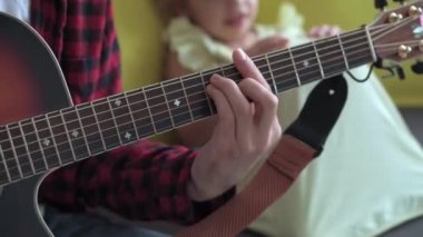 Rock tarzında mutlu bir adam, küçük çocukla rahat evinde gitar çalarak vakit geçirir. Baba küçük tatlı kız için şarkılar söyler müzik enstrümanı yerli müzik dersinin keyfini çıkar. aile, aşk, hayat konsepti