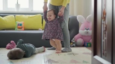 Genç neo beyaz annenin iki küçük çocukla oynadığı sahici yakın plan bebek kız ve anaokulu çocuğu evde eğleniyor. annelik, çocukluk, aile, özgünlük kavramı