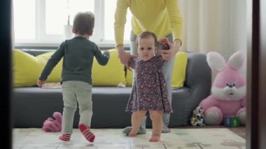 Genç neo beyaz annenin iki küçük çocukla oynadığı sahici yakın plan bebek kız ve anaokulu çocuğu evde eğleniyor. annelik, çocukluk, aile, özgünlük kavramı