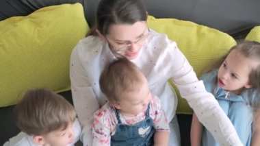 Kafkas ailesi küçük çocukları kız çocuk ve anne akıllı telefonlarıyla video konferansında evdeki oturma odasında mutluluk gülümsemesiyle sohbet ediyorlar. faaliyet teknolojisi yaşam tarzı cep telefonu kullanımı kavramı