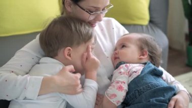 Otantik, genç, beyaz bir kadın çocuklarla ilgileniyor. Annem evde çocuklarla iyi vakit geçiriyor. Küçük anaokulu çocuğu ve annesi ile birlikte evde eğleniyorlar. Annelik, çocukluk kavramı.