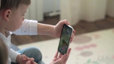 Kafkas ailesi küçük çocukları kız çocuk ve anne akıllı telefonlarıyla video konferansında evdeki oturma odasında mutluluk gülümsemesiyle sohbet ediyorlar. faaliyet teknolojisi yaşam tarzı cep telefonu kullanımı kavramı