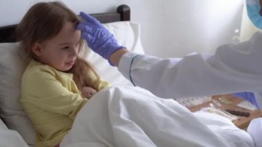 Bebek aşılanmaktan korkuyor. Genç, beyaz kadın hemşire ya da doktor çocuk doktoru beyaz yatakta reşit olmayan kızlara aşı yapıyor. ilaç ve sağlık, pediatri, covid-19 konsepti