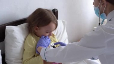 Otantik şirin beyaz kadın hemşire ya da doktor çocuk doktoru hastanede beyaz yatakta statoskop minör anaokulu çocuğu ile muayene ediyor. ilaç ve sağlık, pediatri, covid-19 konsepti