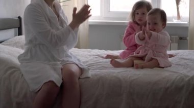 Mutlu birleşik aile, Coronavirüs salgınına karşı savaşan sağlık görevlilerini, doktorları ve kahramanları alkışlıyor. Annem ve çocuklar banyodan çıktıktan sonra Oposite penceresinde bornoz giyerler. Kutlama karantina bitiş konsepti