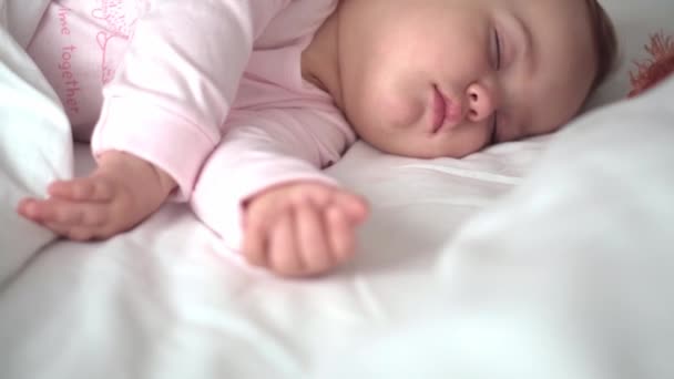 Retrato autêntico bonito caucasiano pequeno bebê gordinha menina ou menino em sono rosa com ursinho de pelúcia na cama branca. criança descansando na hora do almoço. cuidado, criança adormecida, Infância, Paternidade, conceito de vida — Vídeo de Stock