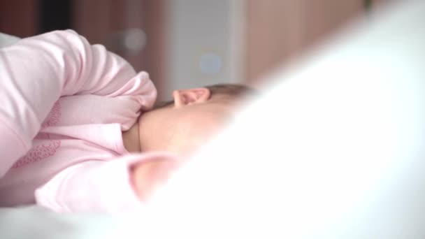 Auténtico retrato lindo bebé caucásico regordete niña o niño en sueño rosa con oso de peluche en la cama blanca. niño descansando a la hora del almuerzo. cuidado, Niñez durmiente, Infancia, paternidad, concepto de vida — Vídeo de stock